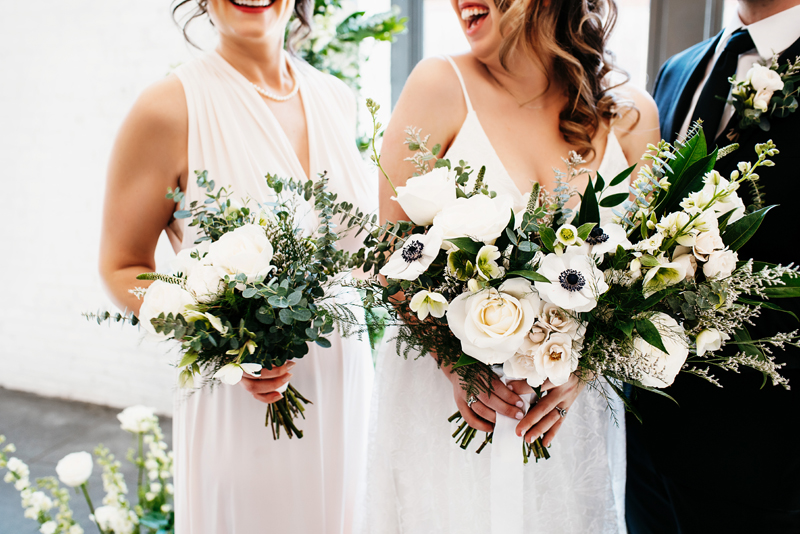 wedding photography, bridesmaid amd bride standing with flowers